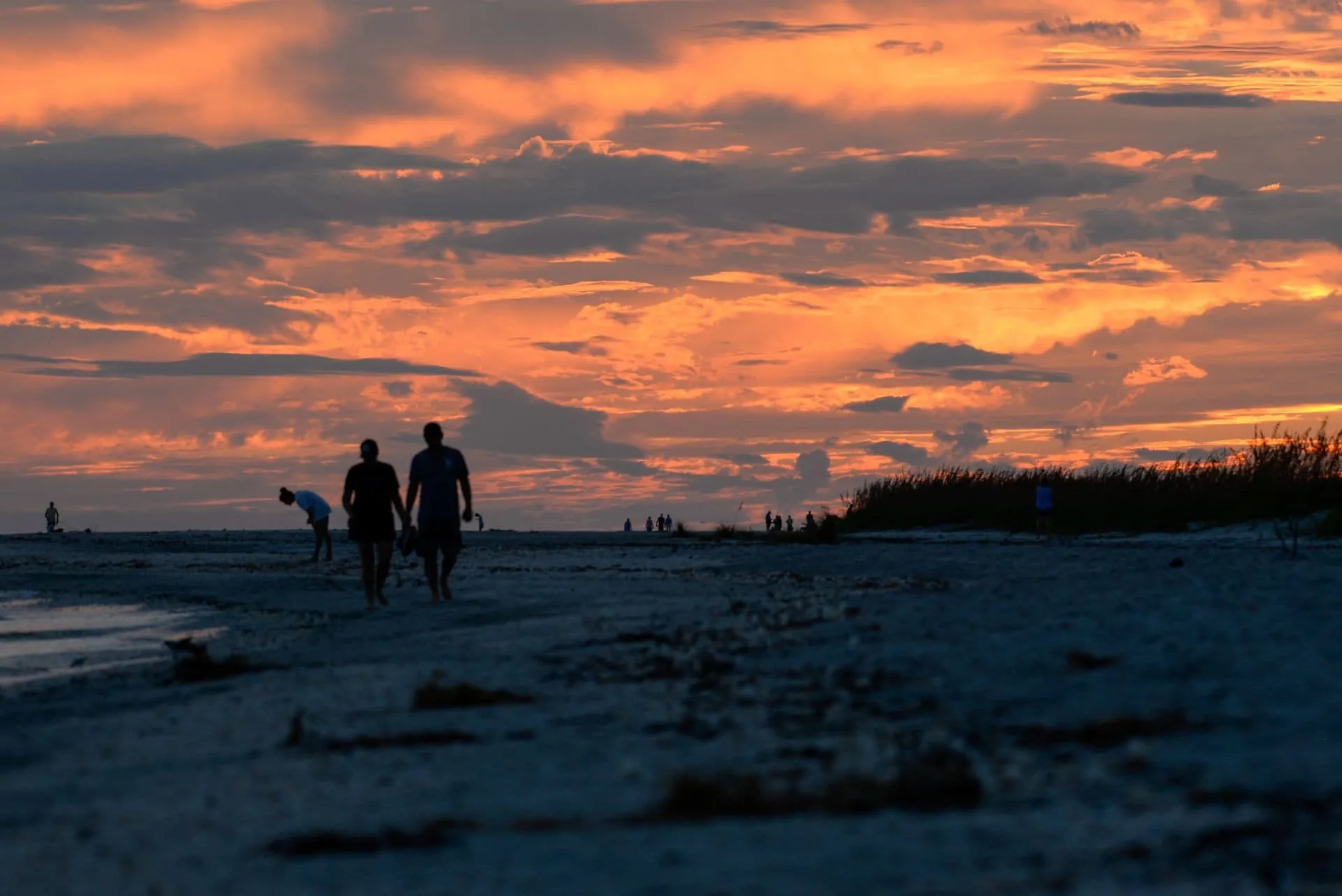 People walking along the beach at sunset in Southwest Florida