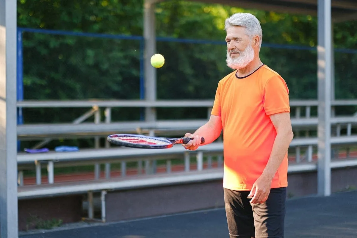 Active senior man playing tennis outdoors